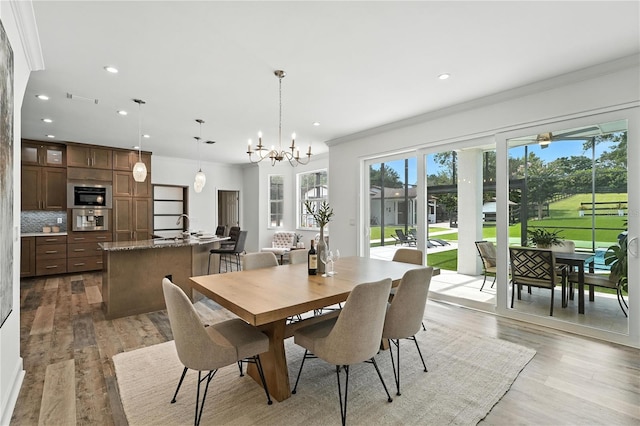 15350 Arabian Way, Montverde, FL 34756 - dining area featuring ornamental molding, recessed lighting, light wood-style floors, and a chandelier