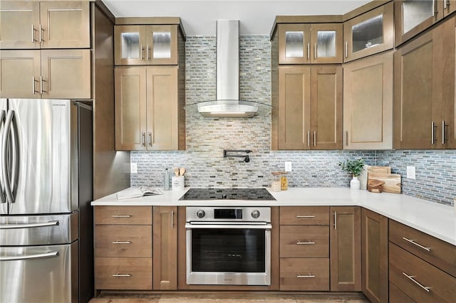 15350 Arabian Way, Montverde, FL 34756 - kitchen with appliances with stainless steel finishes, wall chimney range hood, backsplash, light countertops, and glass insert cabinets