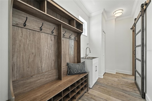 15350 Arabian Way, Montverde, FL 34756 - mudroom featuring a barn door, ornamental molding, and light wood-type flooring