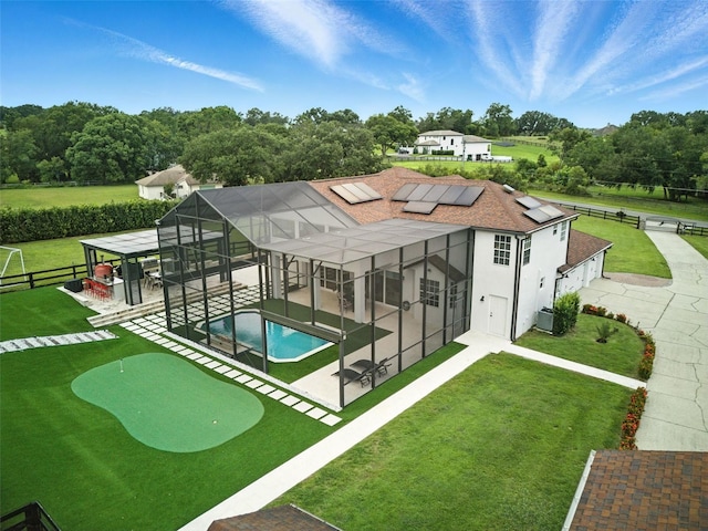 15350 Arabian Way, Montverde, FL 34756 - rear view of property with a patio area, a putting green, a fenced backyard, an outdoor pool, and solar panels