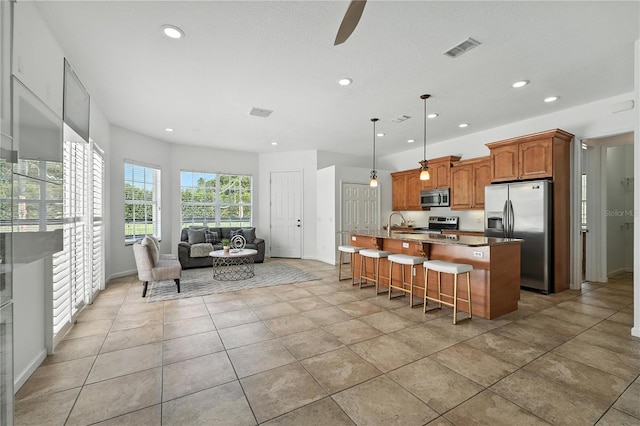 15350 Arabian Way, Montverde, FL 34756 - kitchen with stainless steel appliances, recessed lighting, open floor plan, a center island with sink, and a kitchen breakfast bar