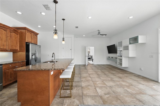 15350 Arabian Way, Montverde, FL 34756 - kitchen featuring stainless steel fridge, recessed lighting, dark stone countertops, brown cabinetry, and open floor plan