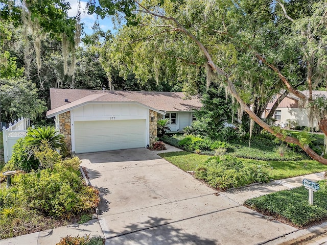 877 Great Bend Rd, Altamonte Springs, FL 32714 - view of front of house with stone siding, driveway, an attached garage, and roof with shingles
