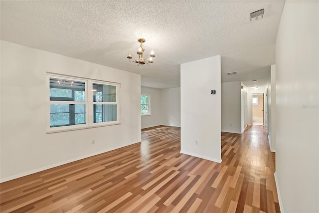 877 Great Bend Rd, Altamonte Springs, FL 32714 - empty room featuring a chandelier, light wood-type flooring, and a textured ceiling