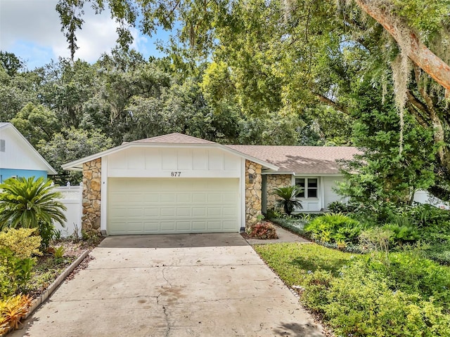 877 Great Bend Rd, Altamonte Springs, FL 32714 - view of front of house featuring stone siding, driveway, an attached garage, and a shingled roof