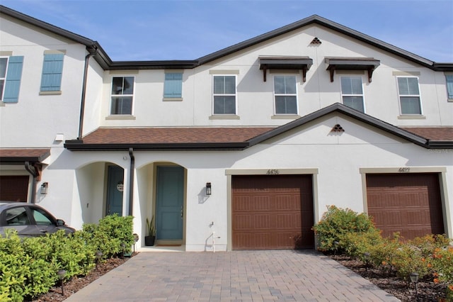 4426 Small Creek Rd, Kissimmee, FL 34744 - view of front of house with stucco siding, an attached garage, and driveway