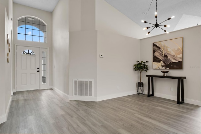2898 Picadilly Cir, Kissimmee, FL 34747 - entrance foyer with high vaulted ceiling, a chandelier, and wood finished floors