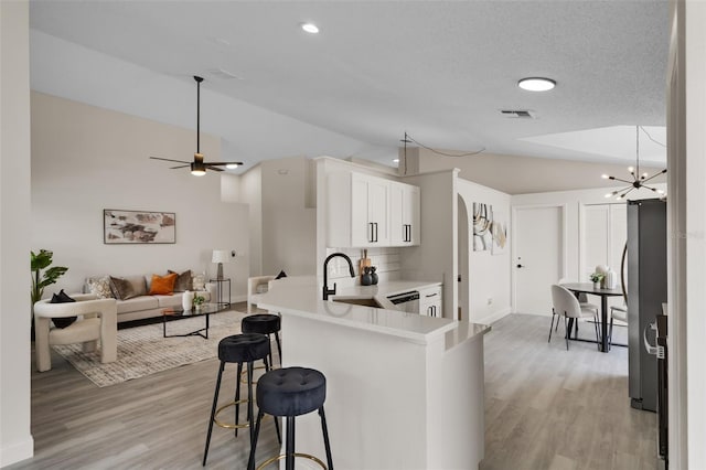 2898 Picadilly Cir, Kissimmee, FL 34747 - kitchen featuring lofted ceiling, stainless steel appliances, light wood-type flooring, a kitchen bar, and open floor plan