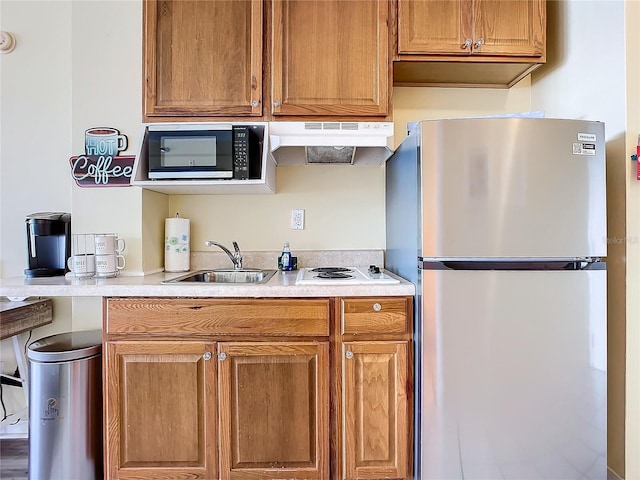 701 S Atlantic Ave Unit 504, Daytona Beach, FL 32118 - kitchen featuring appliances with stainless steel finishes, under cabinet range hood, light countertops, and brown cabinets