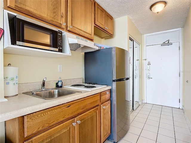 701 S Atlantic Ave Unit 504, Daytona Beach, FL 32118 - kitchen with appliances with stainless steel finishes, brown cabinets, light countertops, light tile patterned flooring, and under cabinet range hood