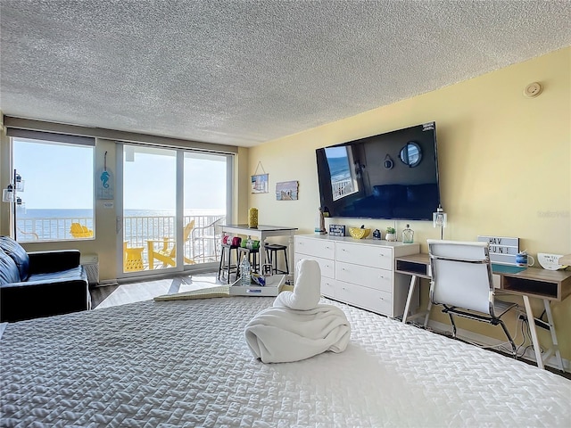 701 S Atlantic Ave Unit 504, Daytona Beach, FL 32118 - bedroom with access to exterior, a textured ceiling, and a water view