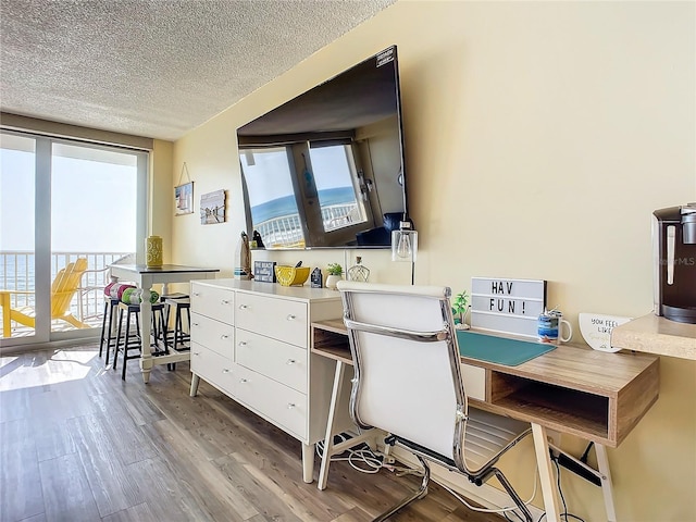 701 S Atlantic Ave Unit 504, Daytona Beach, FL 32118 - office area featuring wood finished floors, plenty of natural light, and a textured ceiling
