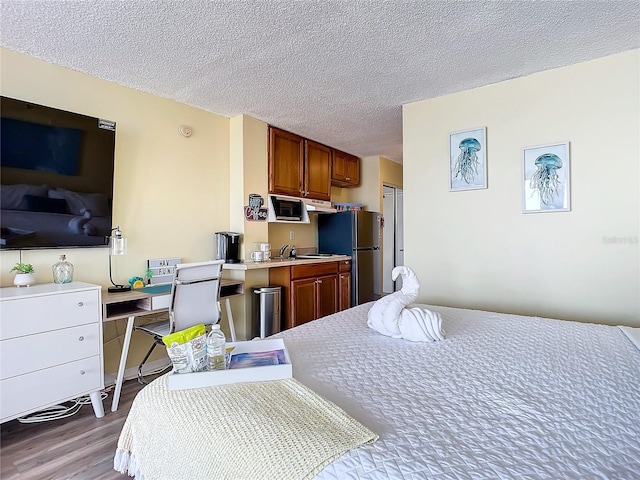 701 S Atlantic Ave Unit 504, Daytona Beach, FL 32118 - bedroom with freestanding refrigerator, wood finished floors, and a textured ceiling