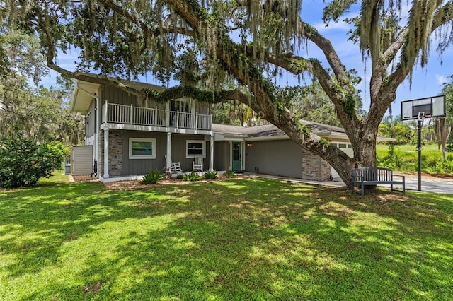 11815 Lake Susan, Clermont, FL 34711 - view of front of property featuring stone siding, a front lawn, a balcony, and board and batten siding