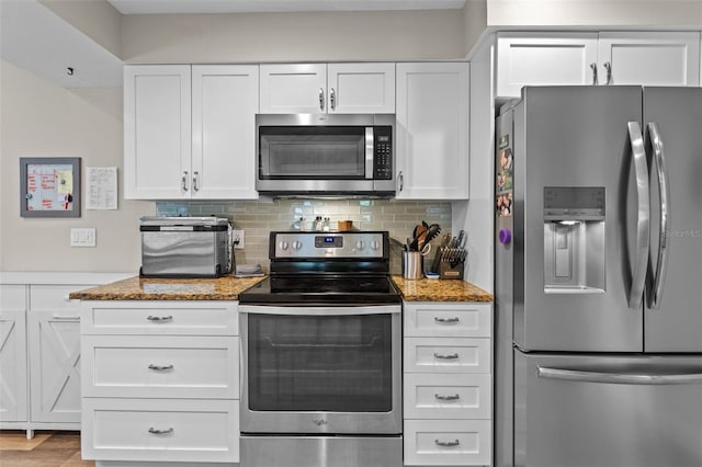 11815 Lake Susan, Clermont, FL 34711 - kitchen with appliances with stainless steel finishes, white cabinetry, light stone counters, and decorative backsplash
