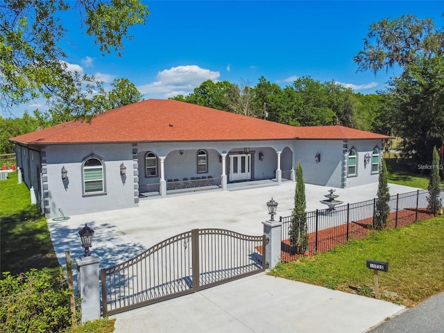 15715 Trousdale St, Clermont, FL 34715 - mediterranean / spanish-style home with a fenced front yard, stucco siding, a gate, and concrete driveway
