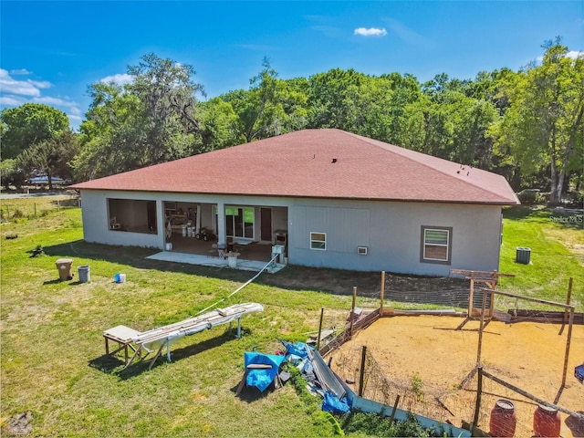 15715 Trousdale St, Clermont, FL 34715 - back of property featuring a lawn, roof with shingles, and a patio