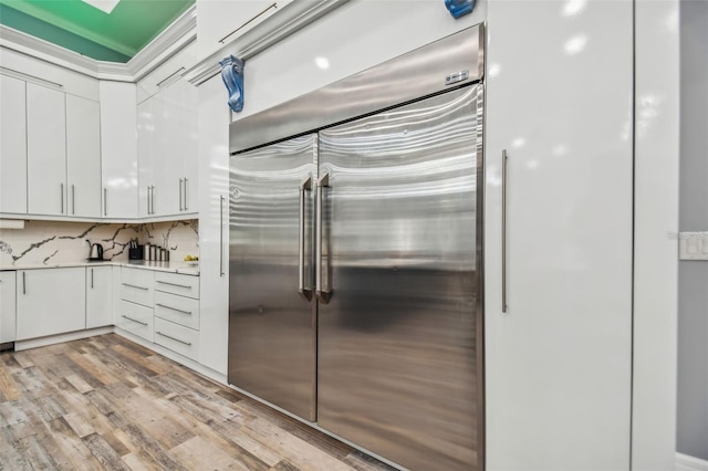 15715 Trousdale St, Clermont, FL 34715 - kitchen featuring built in refrigerator, white cabinetry, light wood-style floors, light countertops, and backsplash