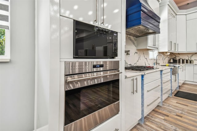 15715 Trousdale St, Clermont, FL 34715 - kitchen featuring stainless steel appliances, custom range hood, light wood finished floors, and light countertops