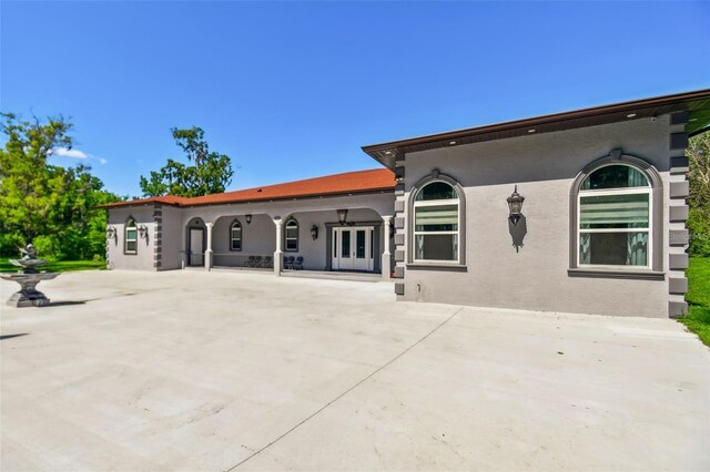 15715 Trousdale St, Clermont, FL 34715 - back of property with stucco siding, a patio, and french doors