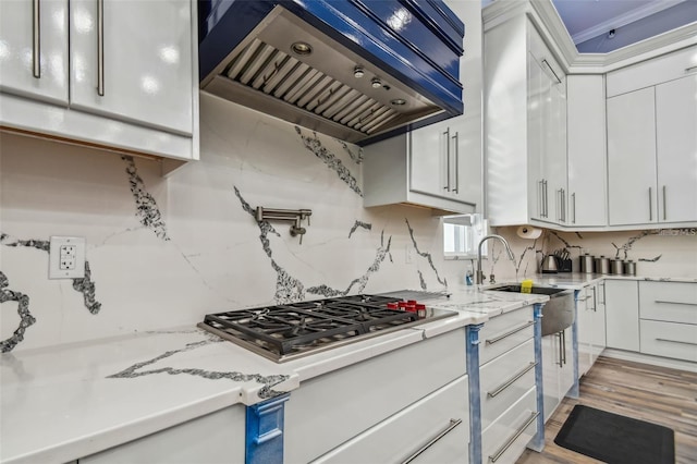 15715 Trousdale St, Clermont, FL 34715 - kitchen with custom range hood, stainless steel gas stovetop, white cabinets, and tasteful backsplash