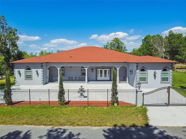 15715 Trousdale St, Clermont, FL 34715 - mediterranean / spanish-style home featuring stucco siding, driveway, a gate, a fenced front yard, and a porch