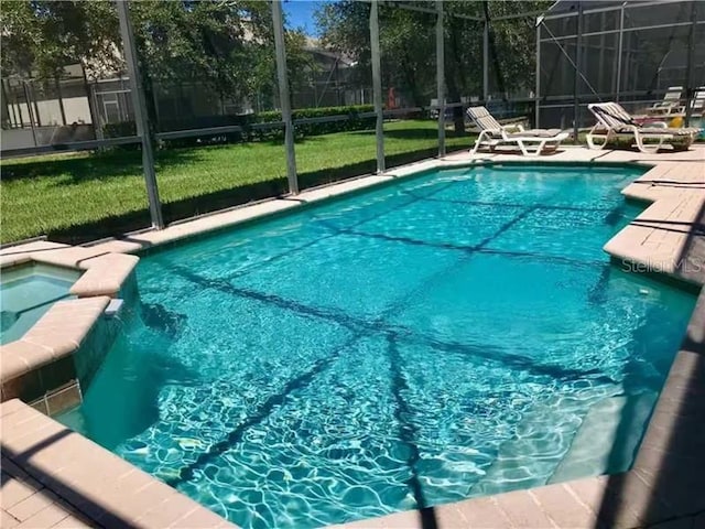 7763 Tosteth St, Kissimmee, FL 34747 - view of swimming pool featuring glass enclosure, a pool with connected hot tub, a patio, and a yard
