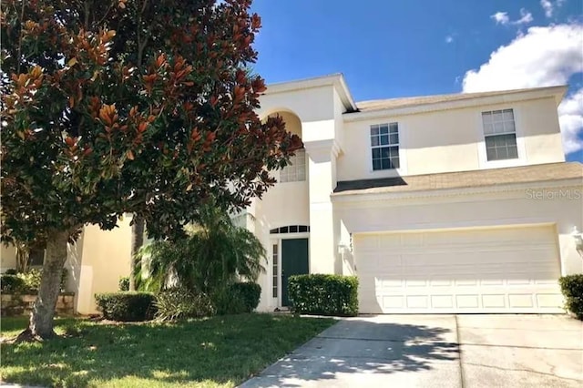 7763 Tosteth St, Kissimmee, FL 34747 - view of front of property featuring stucco siding, concrete driveway, an attached garage, and a front lawn