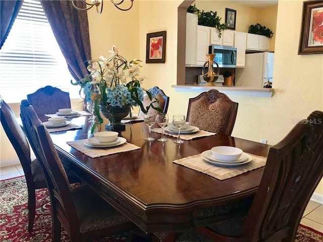 7763 Tosteth St, Kissimmee, FL 34747 - tiled dining room with a chandelier