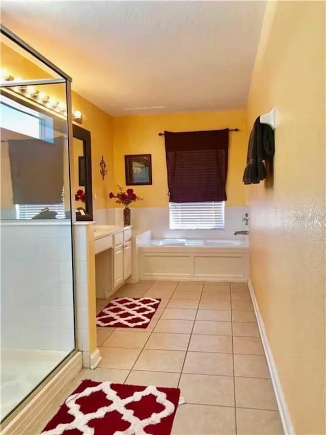 7763 Tosteth St, Kissimmee, FL 34747 - bathroom featuring tile patterned flooring, a bath, a stall shower, and vanity