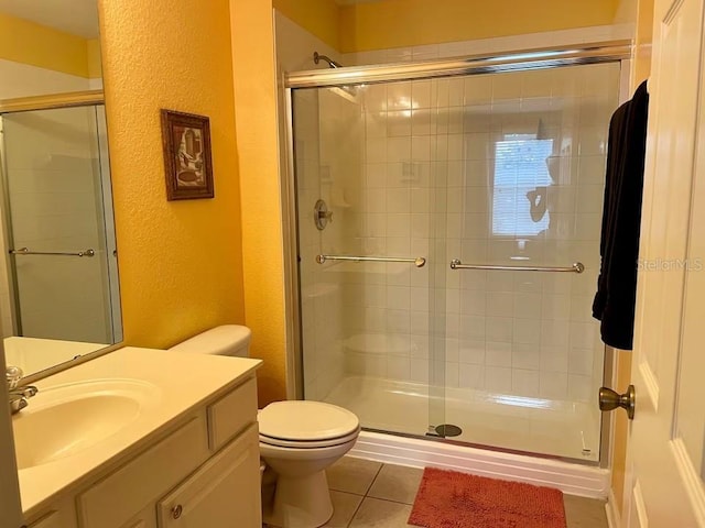 7763 Tosteth St, Kissimmee, FL 34747 - bathroom featuring a textured wall, vanity, a shower stall, and tile patterned floors