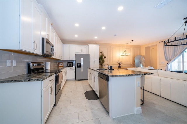 1660 Tropical Palms Cir, Kissimmee, FL 34747 - kitchen featuring appliances with stainless steel finishes, decorative backsplash, open floor plan, white cabinetry, and recessed lighting