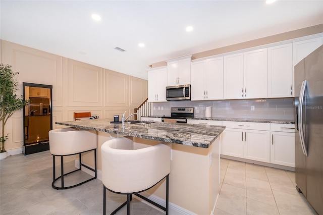 1660 Tropical Palms Cir, Kissimmee, FL 34747 - kitchen featuring appliances with stainless steel finishes, decorative backsplash, a kitchen breakfast bar, stone counters, and recessed lighting
