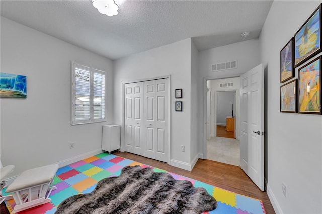 8827 Arrabida Ln, Orlando, FL 32836 - bedroom featuring wood finished floors, a textured ceiling, and a closet
