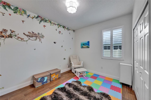 8827 Arrabida Ln, Orlando, FL 32836 - playroom featuring a textured ceiling and wood finished floors