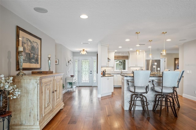 9070 Ron Den Ln, Windermere, FL 34786 - kitchen with high quality fridge, a kitchen bar, a kitchen island, dark wood-style flooring, and recessed lighting