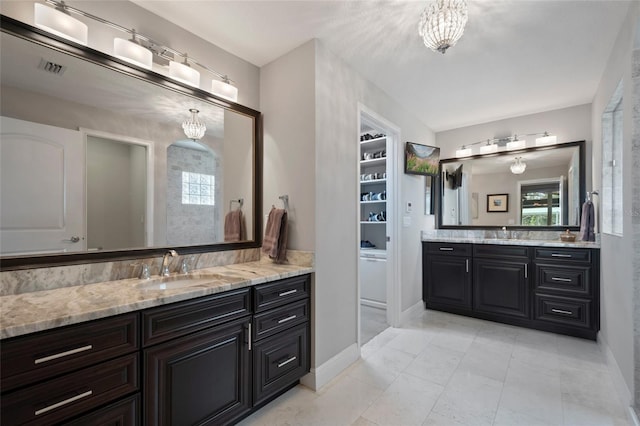 9070 Ron Den Ln, Windermere, FL 34786 - bathroom featuring a chandelier and two vanities