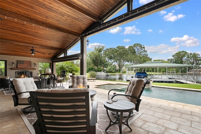 9070 Ron Den Ln, Windermere, FL 34786 - view of patio / terrace with a water view, ceiling fan, an outdoor living space with a fireplace, an outdoor pool, and boat lift