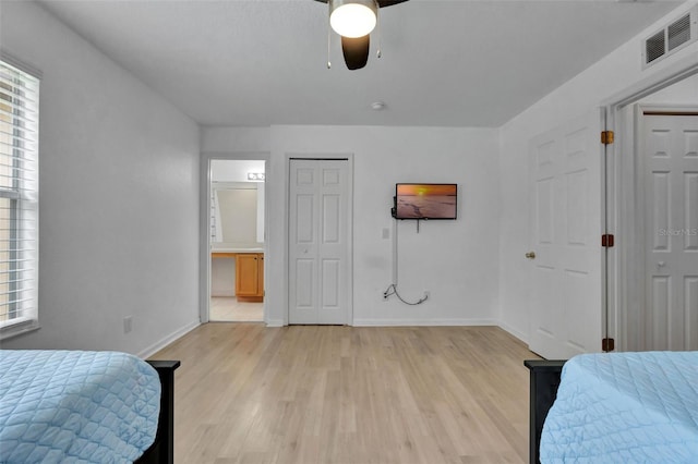 216 Bergamo Dr, Davenport, FL 33897 - bedroom with multiple windows, light wood-style flooring, connected bathroom, and ceiling fan