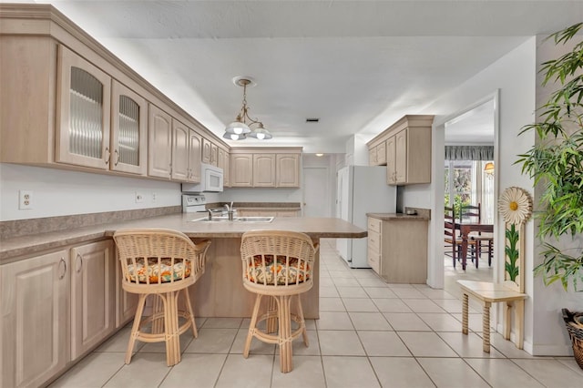 1238 Palmetto Rd, Eustis, FL 32726 - kitchen with white appliances, a breakfast bar area, a peninsula, glass insert cabinets, and light tile patterned floors