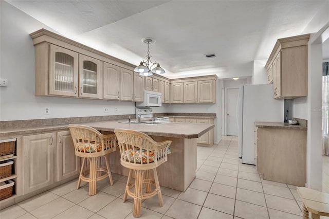 1238 Palmetto Rd, Eustis, FL 32726 - kitchen featuring white appliances, a breakfast bar, light tile patterned floors, glass insert cabinets, and a peninsula