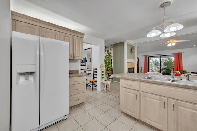 1238 Palmetto Rd, Eustis, FL 32726 - kitchen with white refrigerator with ice dispenser, light brown cabinets, a tile fireplace, and light tile patterned floors
