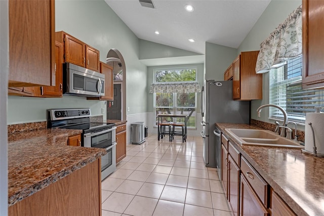 1041 Mccully Ct, Oviedo, FL 32765 - kitchen featuring appliances with stainless steel finishes, vaulted ceiling, brown cabinetry, dark countertops, and recessed lighting