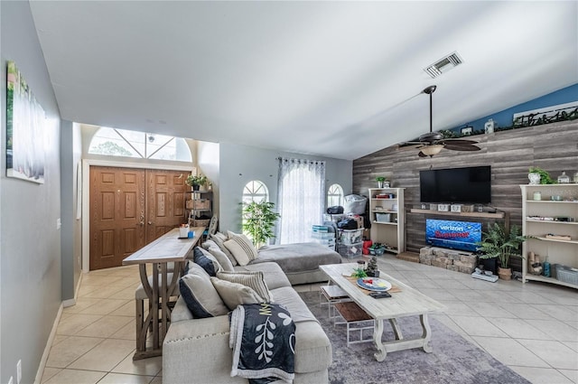 4045 Simkins Ave, North Port, FL 34286 - living area featuring tile patterned floors, vaulted ceiling, ceiling fan, a warm lit fireplace, and an accent wall