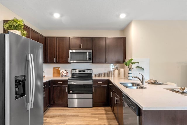 3367 Wynwood Forest Dr, Ocoee, FL 34761 - kitchen featuring stainless steel appliances, a peninsula, dark brown cabinets, light countertops, and recessed lighting