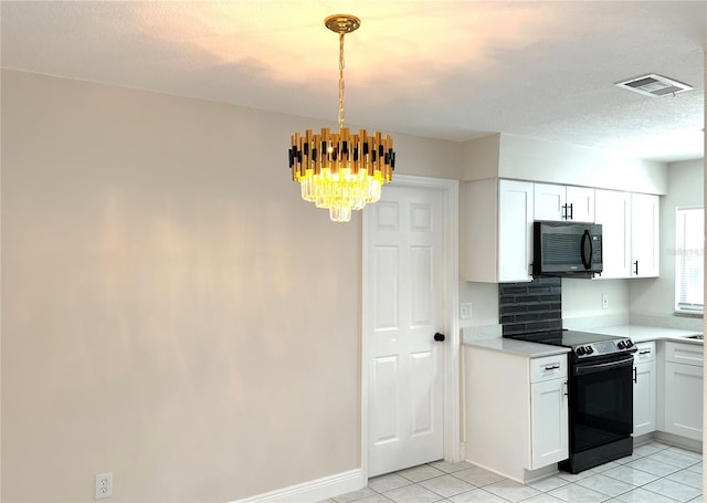 4219 Chateau Rd, Orlando, FL 32808 - kitchen with black appliances, light countertops, a chandelier, light tile patterned flooring, and white cabinets
