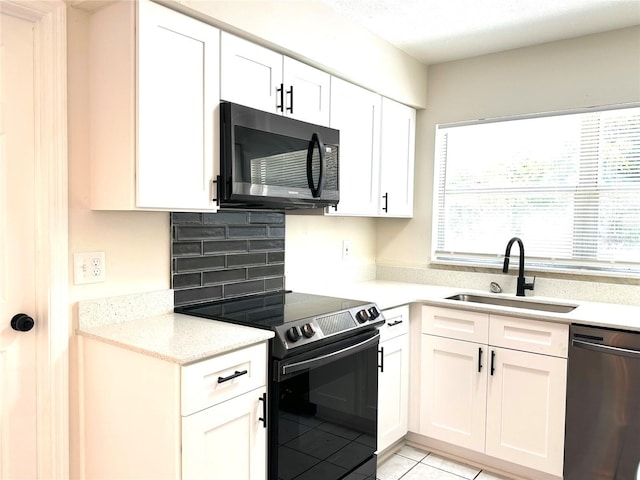 4219 Chateau Rd, Orlando, FL 32808 - kitchen featuring dishwasher, electric stove, white cabinets, light tile patterned flooring, and light stone counters