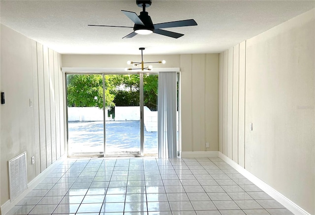 4219 Chateau Rd, Orlando, FL 32808 - spare room featuring a textured ceiling, a chandelier, light tile patterned floors, and a ceiling fan