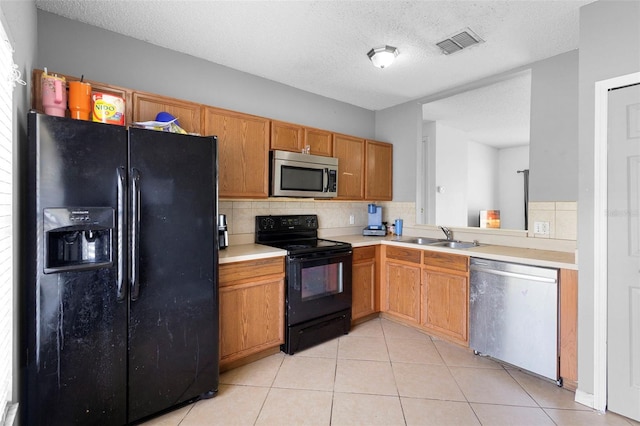 1040 Cannock Dr, Kissimmee, FL 34758 - kitchen featuring black appliances, decorative backsplash, light countertops, light tile patterned flooring, and brown cabinets