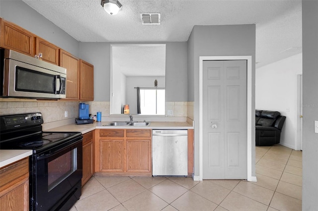 1040 Cannock Dr, Kissimmee, FL 34758 - kitchen featuring stainless steel appliances, light countertops, backsplash, a textured ceiling, and light tile patterned flooring